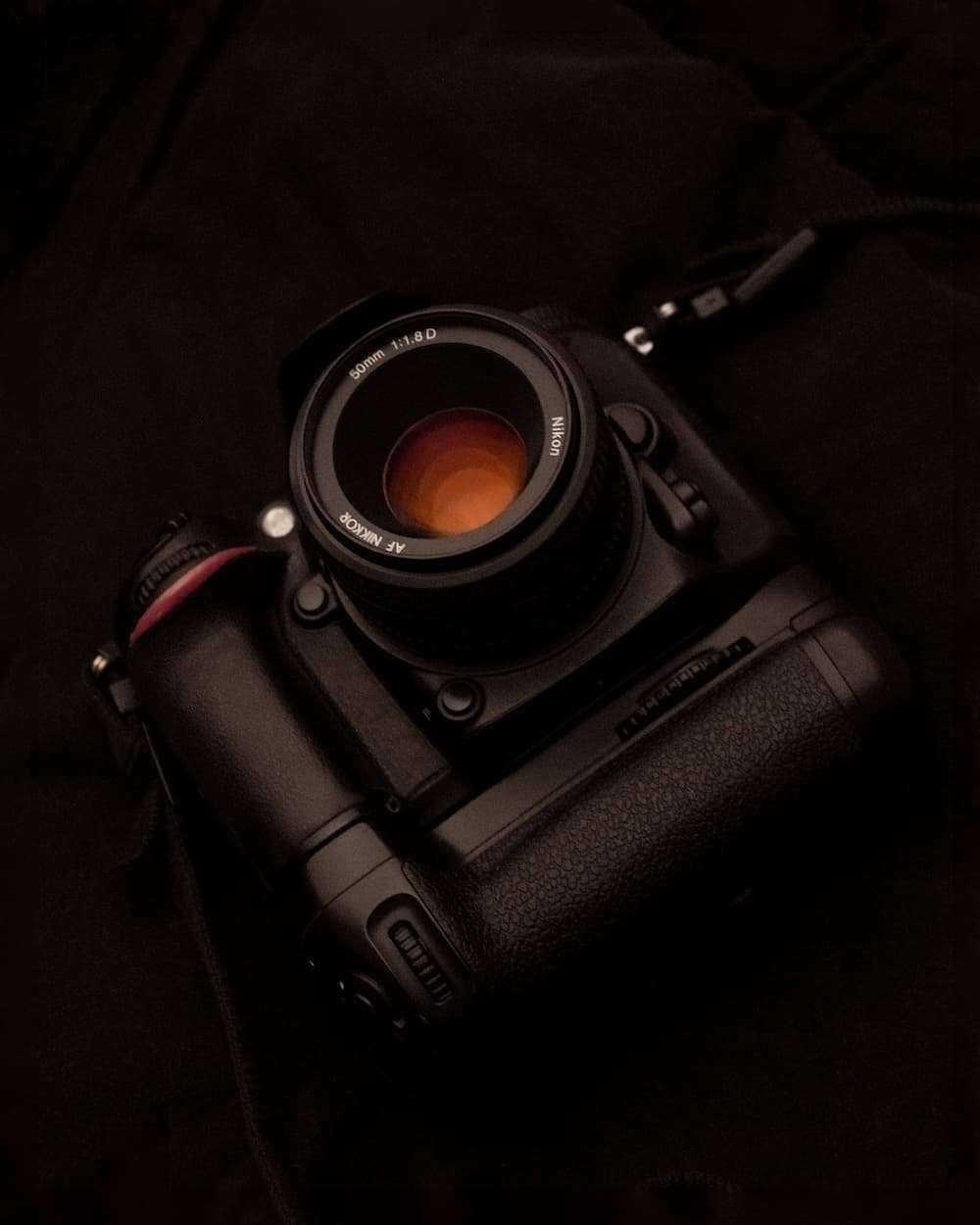 A close-up of a professional camera with an orange lens
