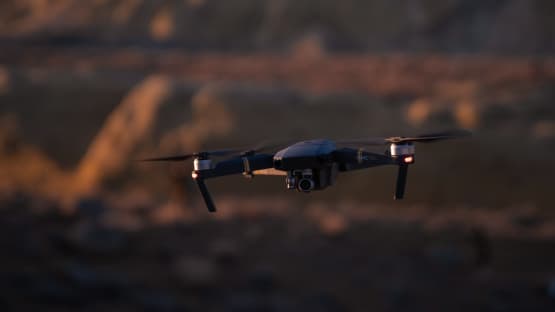 A drone flying over a rocky landscape at dusk